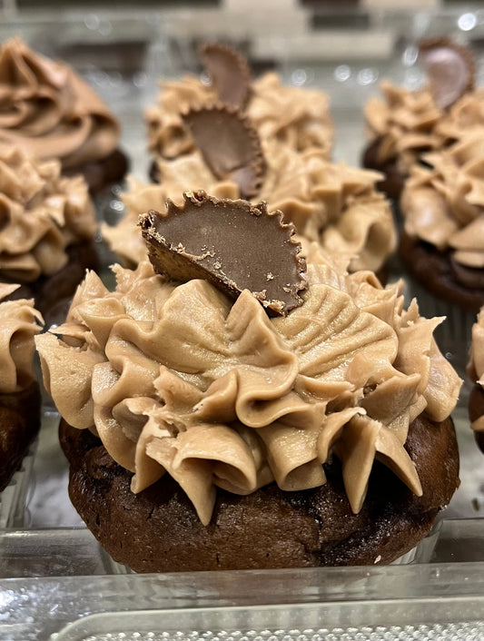 Reese's Cup - A chocolate and peanut butter cake with peanut butter icing, topped with a reese cup. Speciality option - filled with icing or crushed reese cups and chocolate drizzle.
